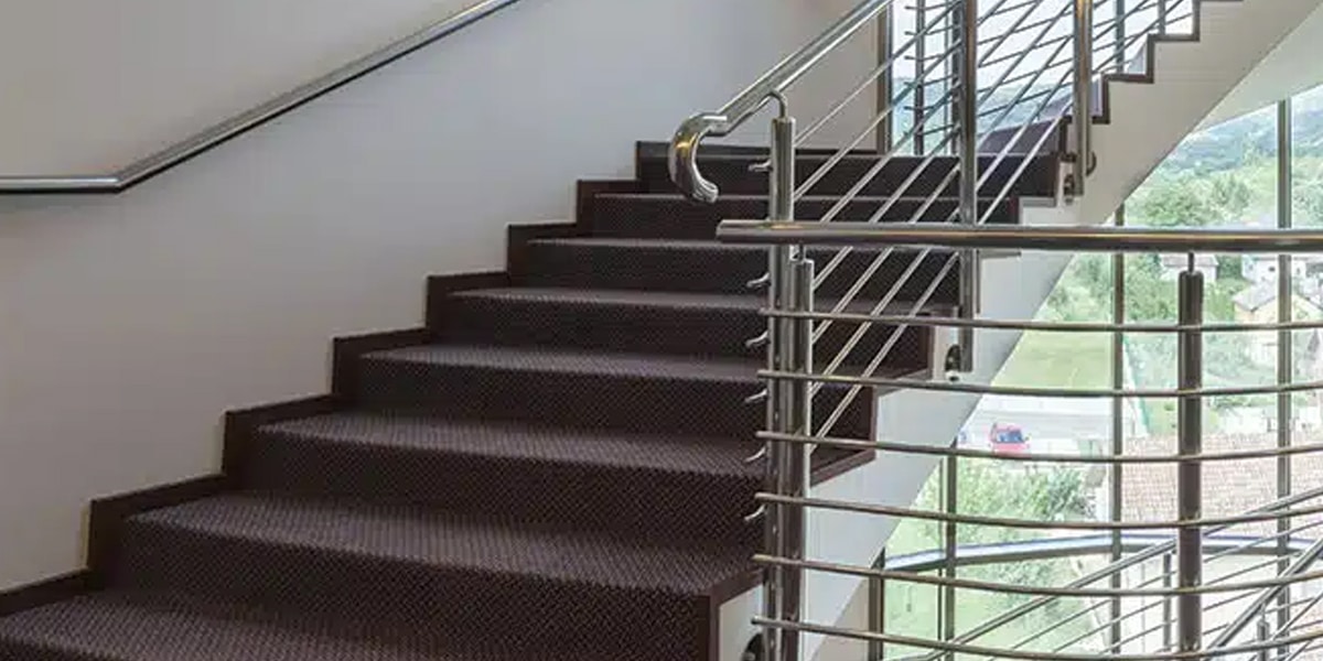 Modern staircase with carpet installation and metal railing, exploring Alternatives to Stair Carpets for stylish and low-maintenance options.