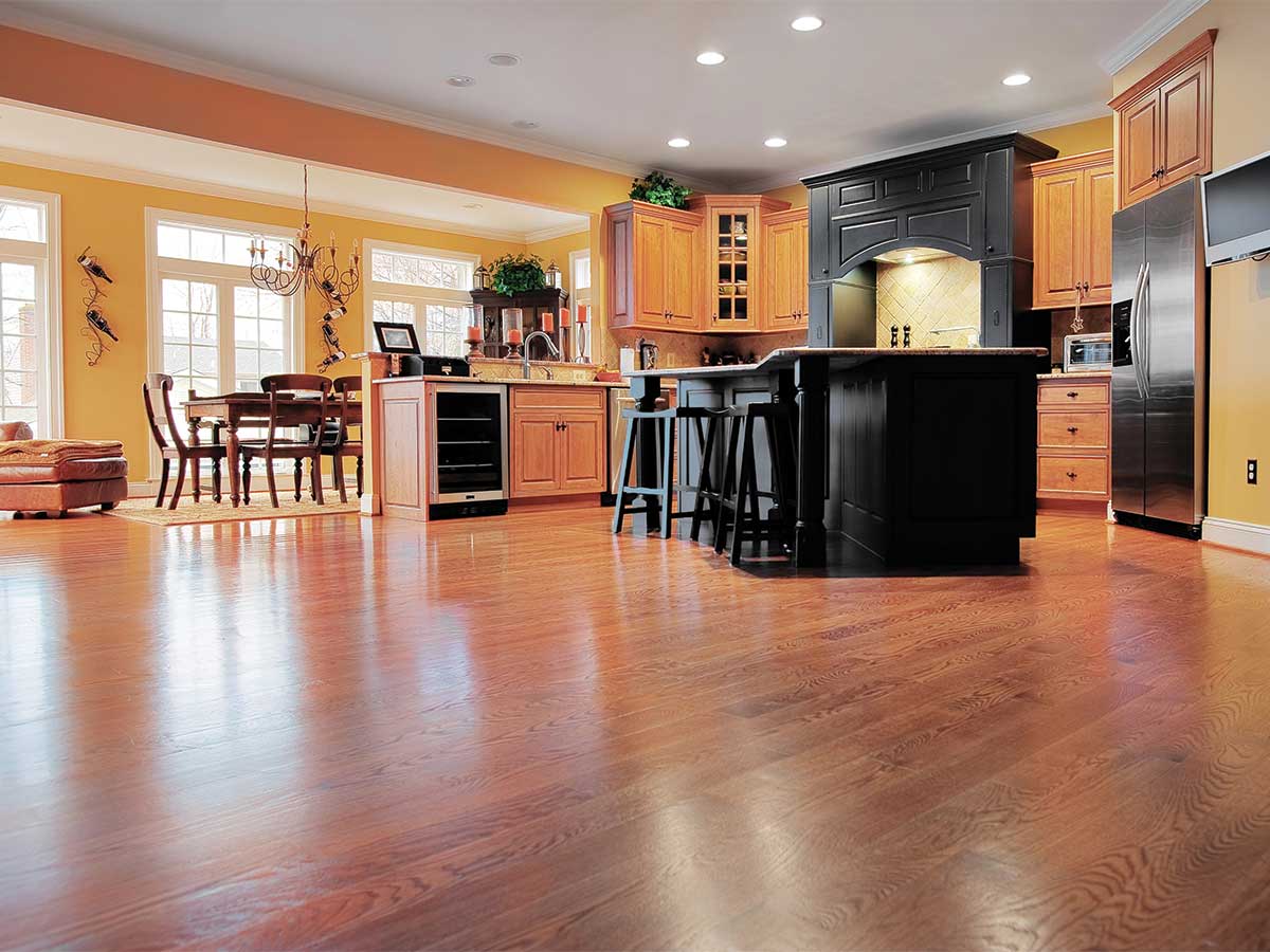A spacious kitchen with hardwood floors and modern appliances raises the question, do hardwood floors make your house colder? As a Denver flooring expert, In Home Flooring can help you understand how hardwood flooring affects your home's temperature and offer solutions for a comfortable living space.