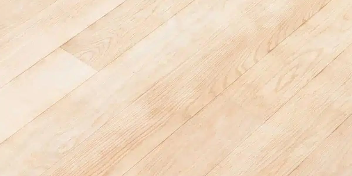 Close-up of light wood laminate flooring texture, showcasing a smooth and modern design by a flooring Denver expert for versatile interior styles.