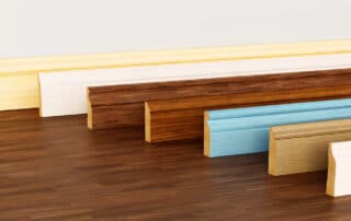 In Home Flooring explores Should Hardwood Floors Match Baseboards with a display of trim styles and colors to show matching and contrasting design choices.