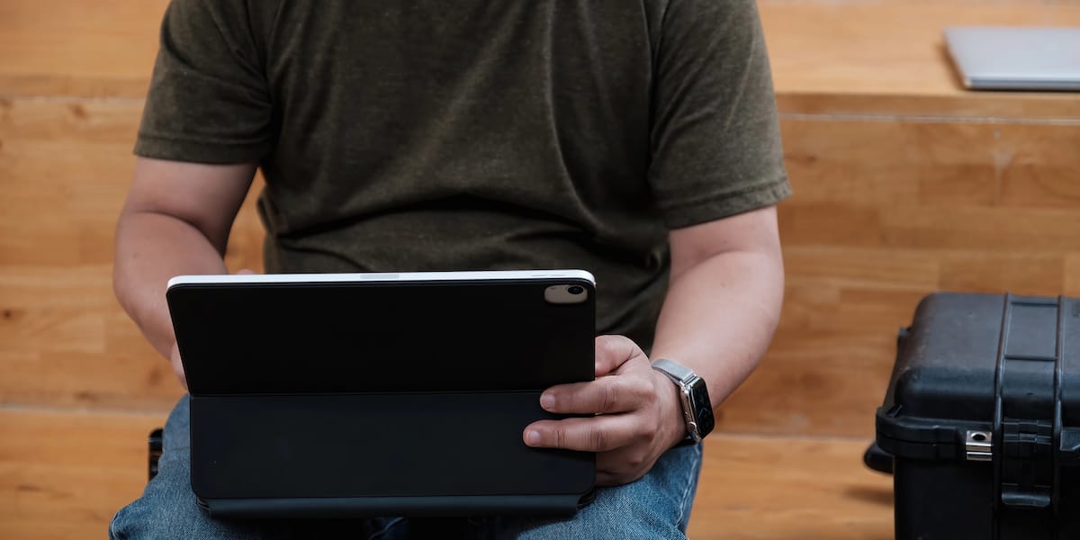 The Mobile Showroom Shift Why Shop-at-Home Is Overtaking Legacy Retail Person using tablet while seated on wooden steps
