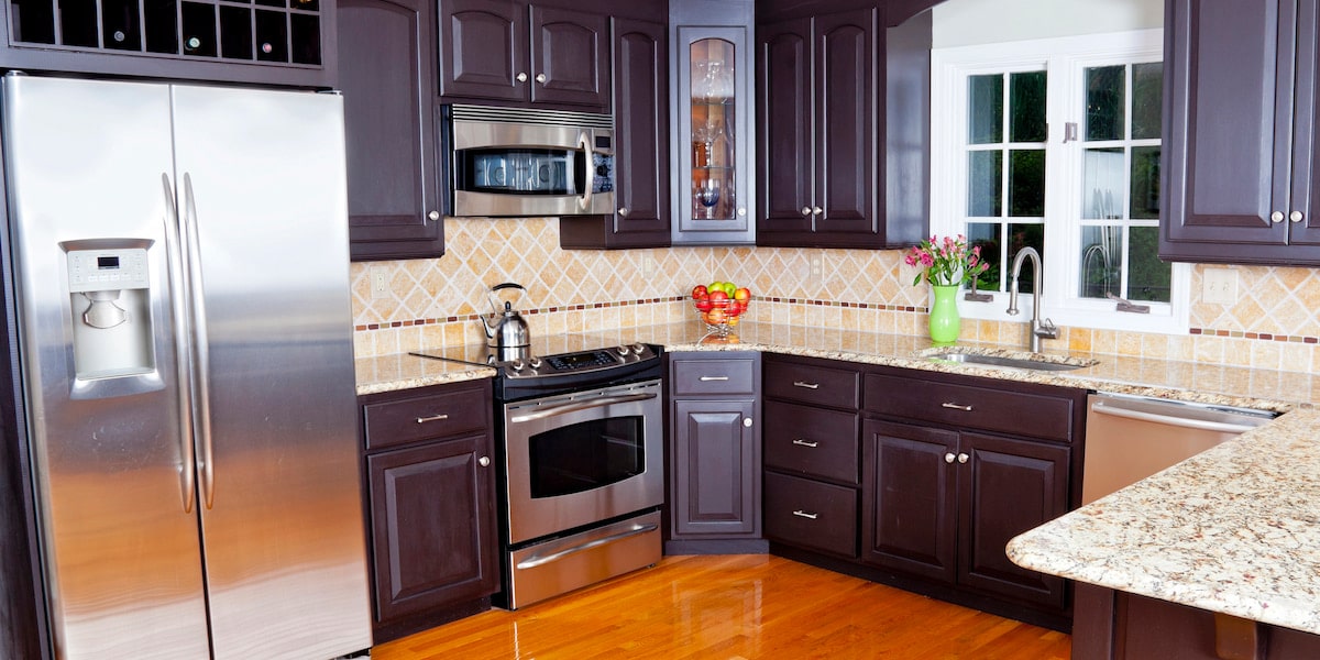 Things To Consider When Choosing Kitchen Splashback Tiles Modern kitchen with dark cabinets and stainless appliances