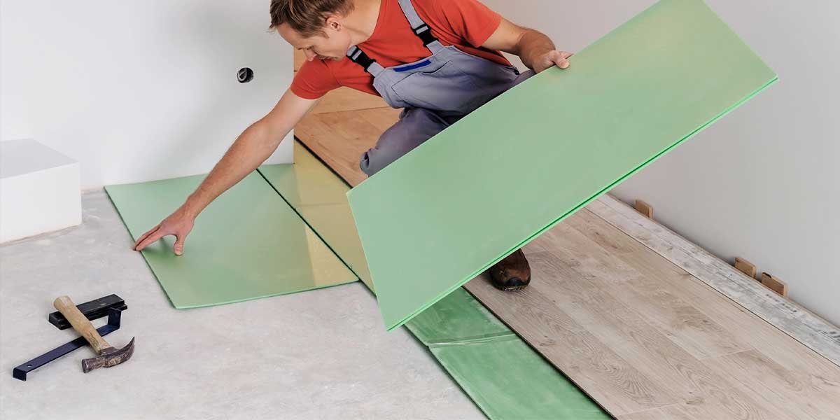 Underlayments Demystified: Sound, Moisture, Thermal—Which to Use Where Man installing green underlayment for laminate flooring - Underlayments Demystified: Sound, Moisture, Thermal—Which to Use Where